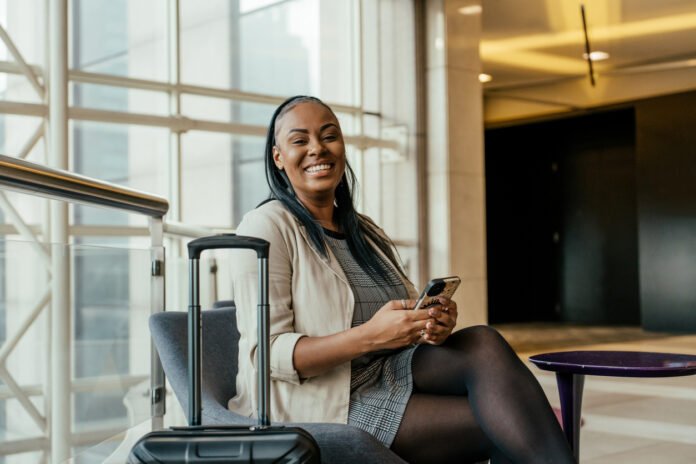 Portrait of businesswoman in hotel lobby holding smartphone