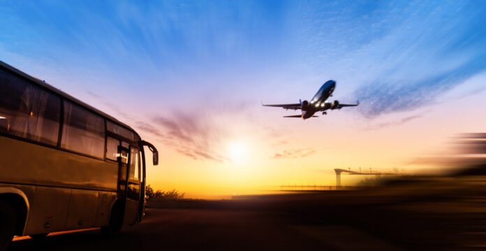 Airplane flying over the highway at sunset