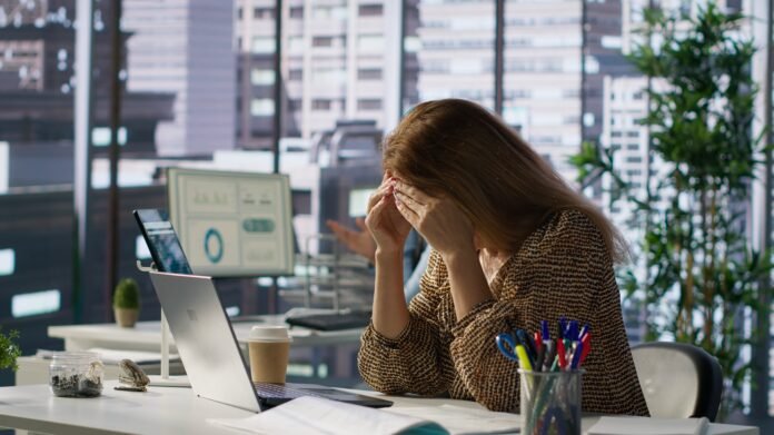 Successful woman battles a headache while managing her financial projects